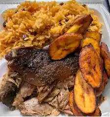 Festival meal with roasted pork, seasoned rice with pigeon peas, and fried sweet plantains.